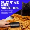 A close-up of a hand using a black reusable roller to clean black cat fur off a yellow knitted sweater